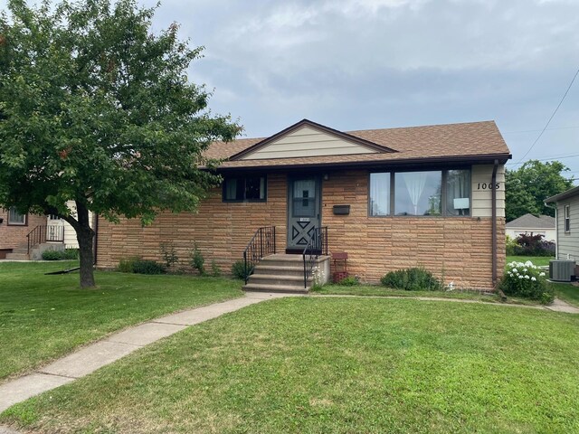 view of front facade with central AC unit and a front lawn