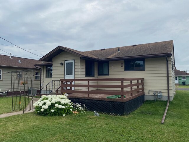 back of house with a yard, a deck, and central AC