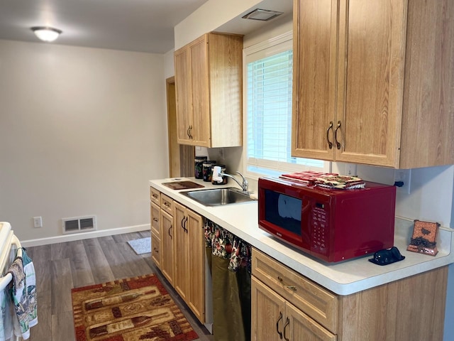 kitchen featuring range, sink, dark hardwood / wood-style floors, and light brown cabinets