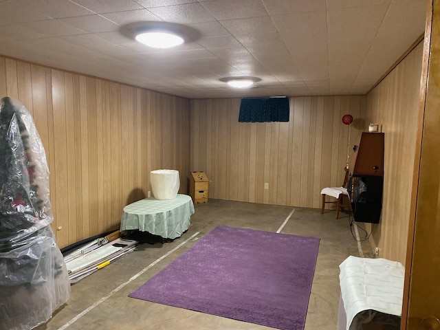 living area with concrete floors and wooden walls