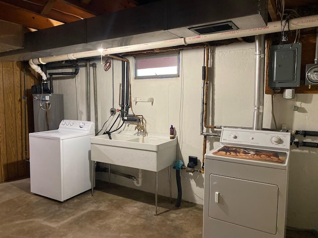 washroom with washing machine and dryer, water heater, sink, electric panel, and wood walls