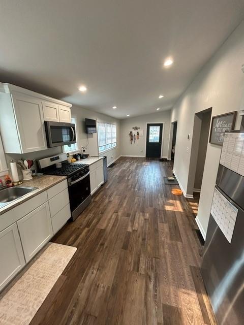 kitchen featuring white cabinetry, appliances with stainless steel finishes, dark hardwood / wood-style floors, and sink