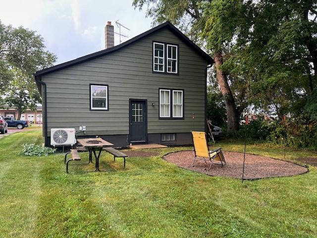 rear view of property with a yard and ac unit