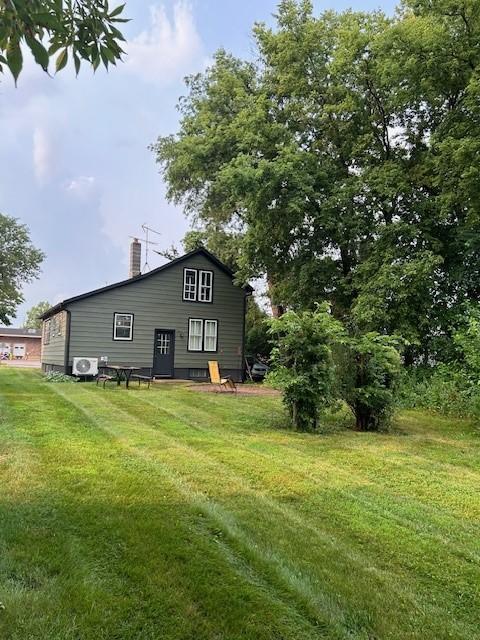 exterior space featuring a lawn and ac unit