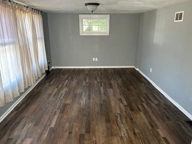 empty room with dark wood-type flooring