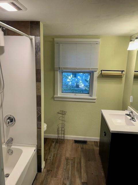 full bathroom featuring shower / tub combination, vanity, toilet, and hardwood / wood-style flooring