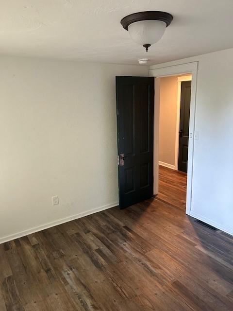 empty room featuring dark hardwood / wood-style flooring