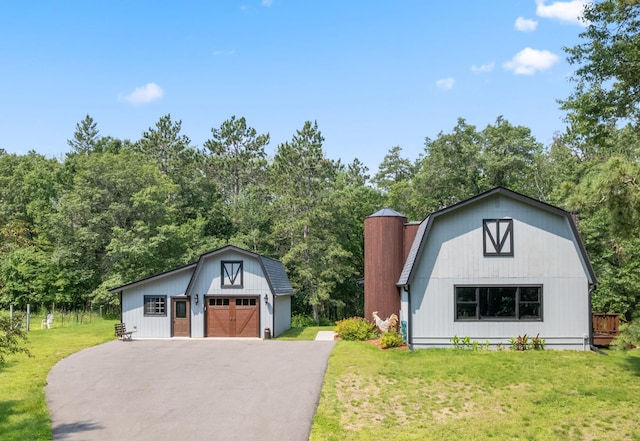 view of front facade featuring an outbuilding, a front lawn, and a garage