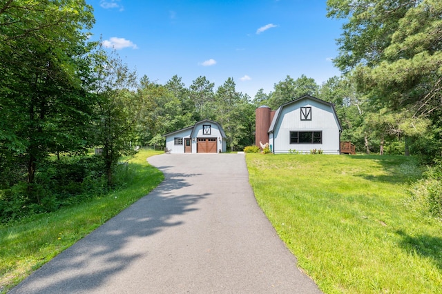 view of front of property with an outdoor structure, a front lawn, and a garage