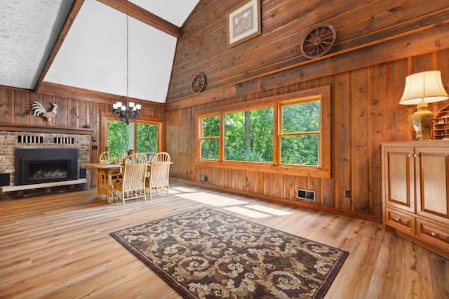 living room with wood walls, hardwood / wood-style floors, and beamed ceiling