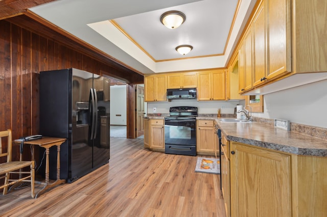 kitchen featuring light brown cabinets, light hardwood / wood-style flooring, a tray ceiling, sink, and black appliances