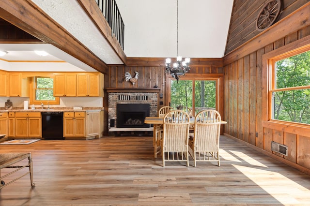 dining area with light wood-type flooring, a wealth of natural light, and wooden walls