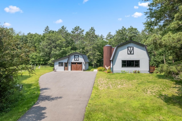 view of front of house with an outdoor structure, a garage, and a front lawn