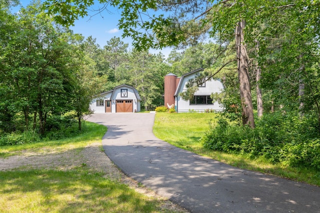 view of front facade featuring an outdoor structure, a garage, and a front lawn