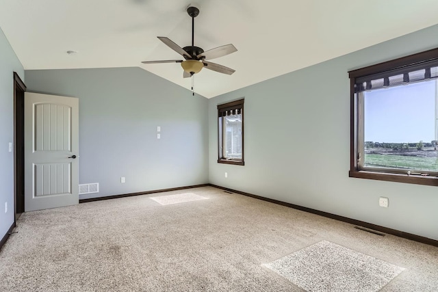 empty room featuring ceiling fan, carpet floors, and vaulted ceiling