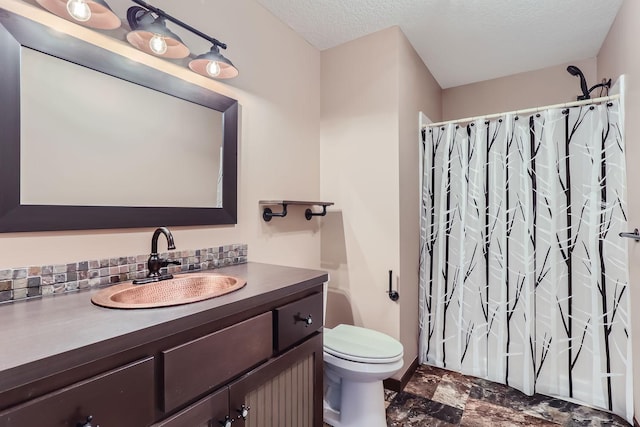 bathroom featuring a shower with curtain, vanity, toilet, and a textured ceiling