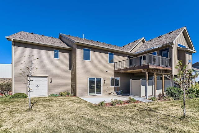 rear view of house with a lawn, a wooden deck, and a patio area