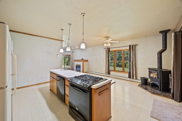 kitchen with ceiling fan, a kitchen island, black gas range, dishwasher, and white fridge