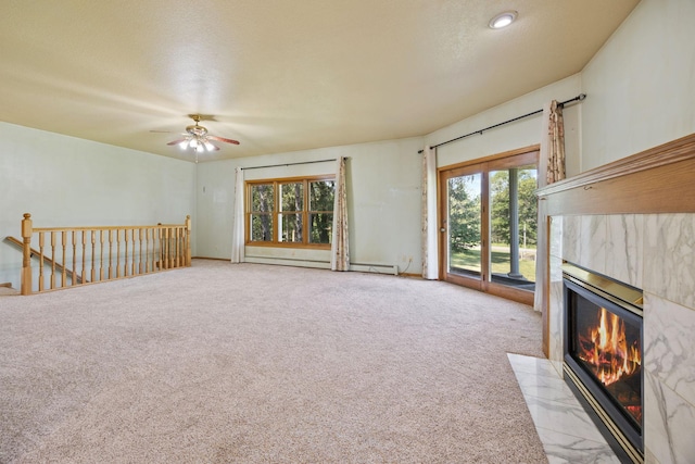 unfurnished living room with light carpet, ceiling fan, a tile fireplace, and a textured ceiling