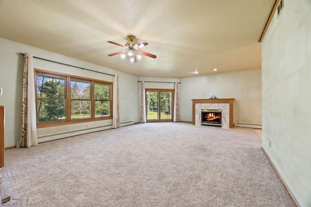 unfurnished living room featuring a premium fireplace, ceiling fan, plenty of natural light, and a textured ceiling