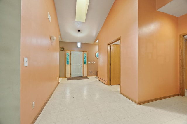 foyer entrance featuring baseboards and high vaulted ceiling