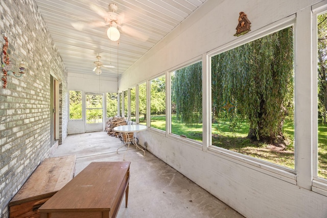 unfurnished sunroom with ceiling fan