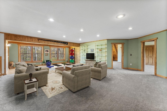 carpeted living room with ornamental molding and wooden walls