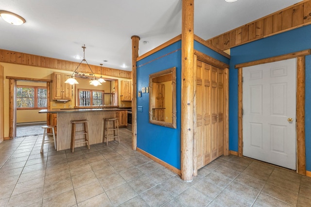 kitchen with a breakfast bar, hanging light fixtures, a baseboard heating unit, and kitchen peninsula