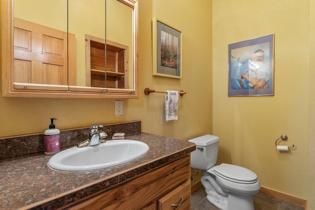 bathroom with toilet, tile patterned floors, and vanity