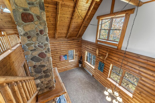 living room with rustic walls, lofted ceiling with beams, wood ceiling, and carpet flooring