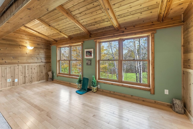 spare room with wood ceiling, wood walls, and lofted ceiling with beams