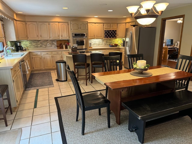 dining space featuring light tile patterned flooring, sink, and a chandelier