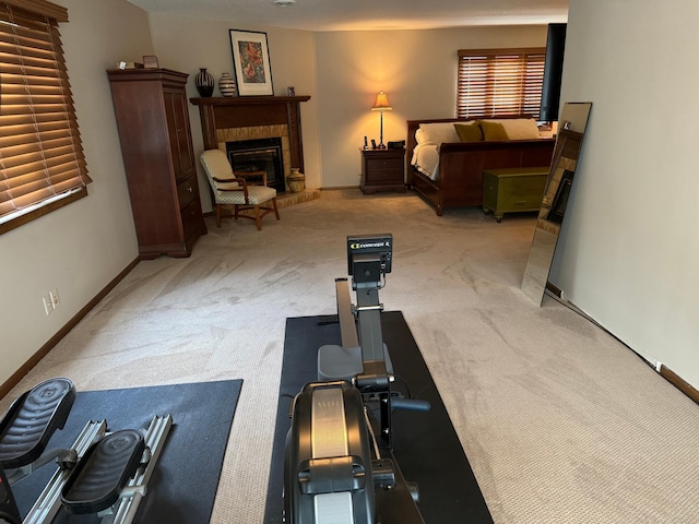 exercise area featuring light carpet and a brick fireplace