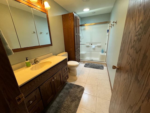 bathroom with vanity, toilet, tile patterned floors, and walk in shower