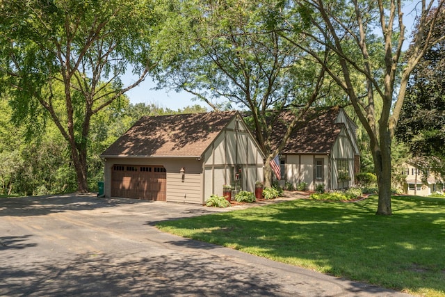 english style home featuring a front yard and a garage