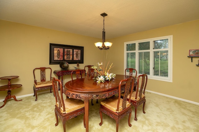 carpeted dining area featuring an inviting chandelier