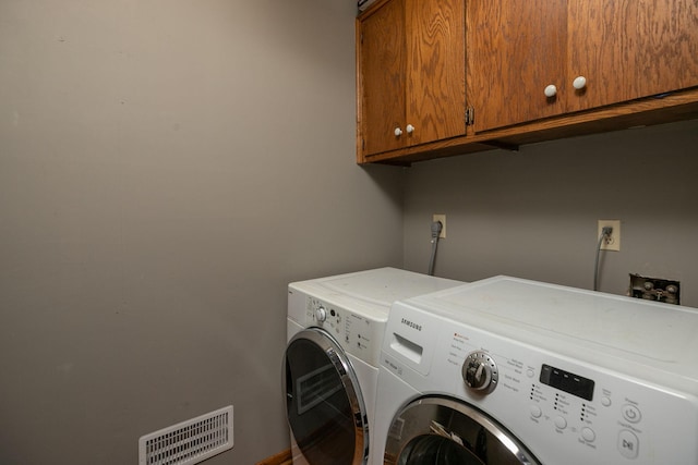 washroom featuring cabinets and separate washer and dryer