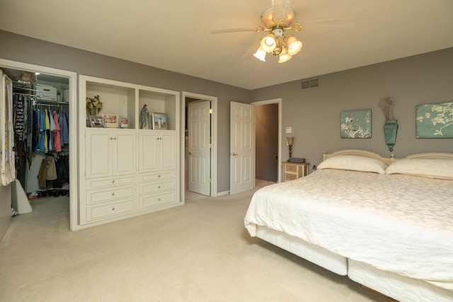 carpeted bedroom featuring a closet, ceiling fan, and a spacious closet