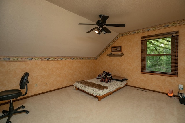 unfurnished bedroom with carpet, a textured ceiling, ceiling fan, and vaulted ceiling