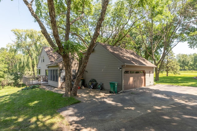 view of side of property with a lawn, a deck, a garage, and an outdoor structure