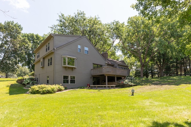 rear view of property featuring a yard and a wooden deck