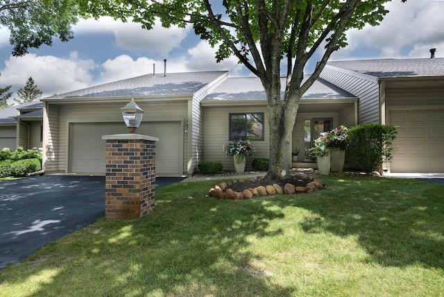 single story home featuring a garage and a front yard