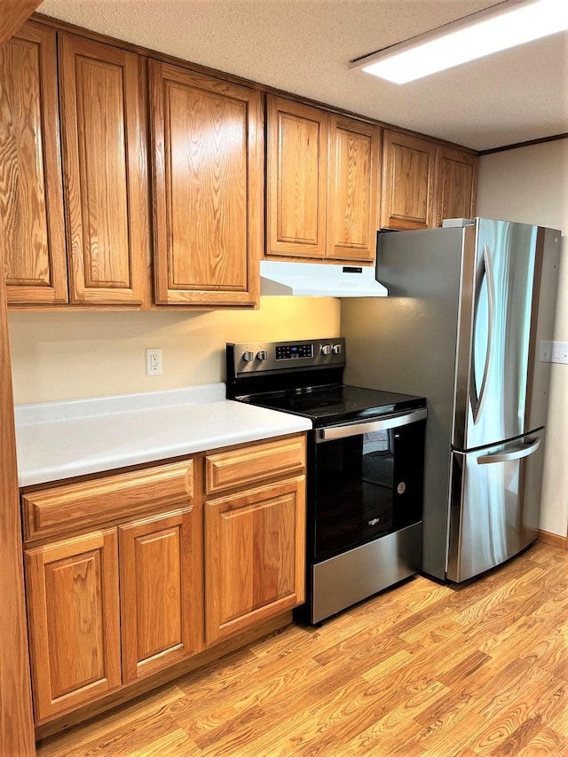 kitchen with a textured ceiling, light hardwood / wood-style flooring, and stainless steel appliances