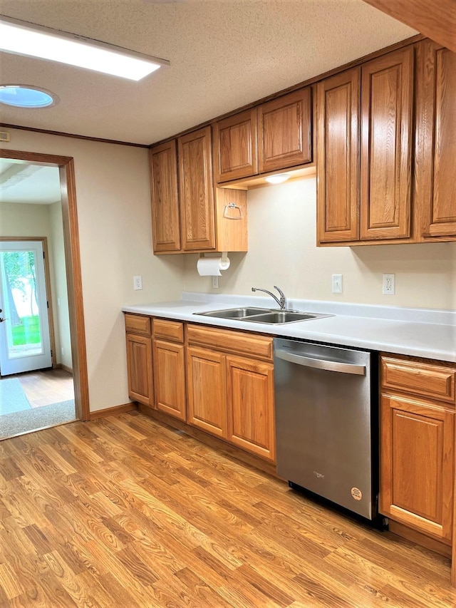 kitchen with sink, a textured ceiling, light hardwood / wood-style flooring, and stainless steel dishwasher