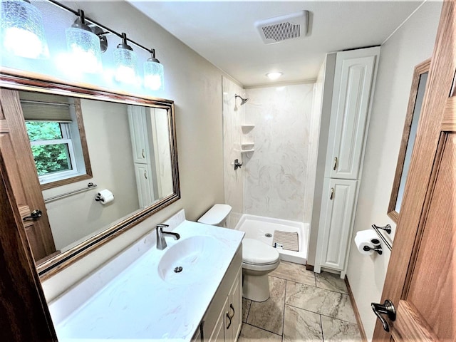 bathroom featuring a tile shower, toilet, and vanity