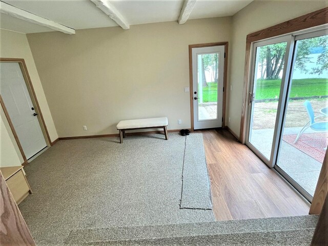 entryway with light hardwood / wood-style floors and beam ceiling