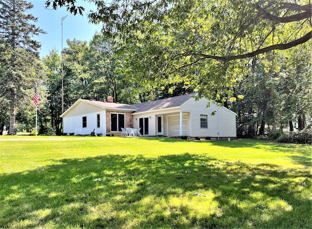 ranch-style house featuring a front yard and a chimney