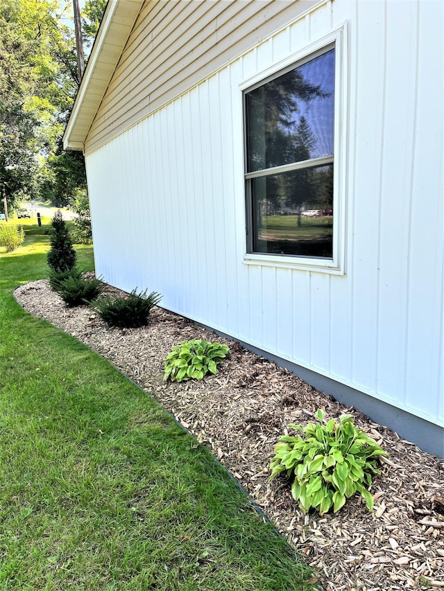 view of home's exterior featuring board and batten siding and a lawn