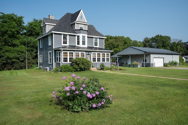 view of front of house with a garage, a sunroom, and a front lawn