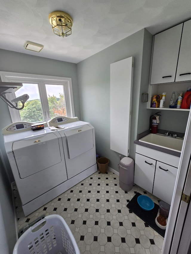 laundry room featuring separate washer and dryer, sink, and cabinets